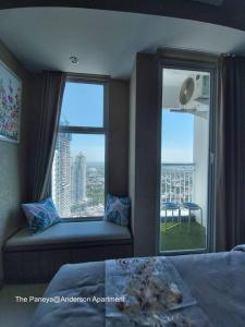 a bedroom with a window seat with a view of a city at The Paneya@Anderson Apartment in Surabaya