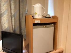 un piccolo frigorifero e un tavolo con un frullatore di Hotel Ikeda a Nagasaki