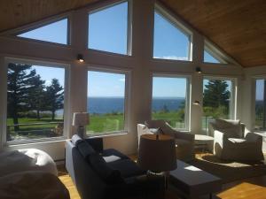 a living room with a large room with large windows at Private Waterfront Luxury on the Bras D'Or Lake in Sydney Forks