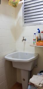 a white sink in a bathroom with a window at APARTAMENTO EM FRENTE A PRAIA in Peruíbe +17 photos