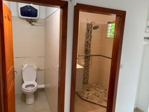 a bathroom with a toilet and a shower at Studio ds résidence sécurisée avec vue & accès à la mer . in Le Moule