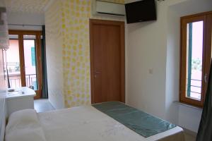 1 dormitorio con 1 cama y TV en Affittacamere Vista Mare en Porto Azzurro