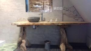 a bathroom with a wooden table with a sink at Home is Home in Camors