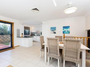 a dining room and kitchen with a table and chairs at Coastal Haven at Gerroa in Gerroa