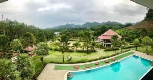 Ban Tha Khun的住宿－塔崑山景旅館，享有度假村游泳池的景致