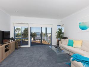 a living room with a couch and a television at Blue Waters at Gerroa in Gerroa