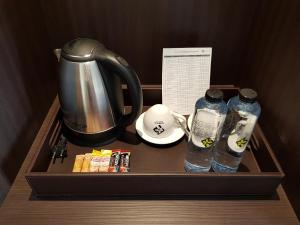 a tray with two bottles of water and a kettle at Nadee 10 Resort & Hotel in Khon Kaen