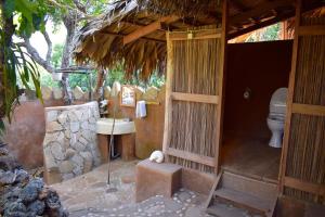 an outside bathroom with a toilet and a sink at Utopia Rote Lodge in Nembrala