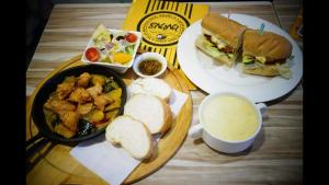 a table with plates of food and a sandwich and a bowl of soup at Yily House怡家居 in Yilan City