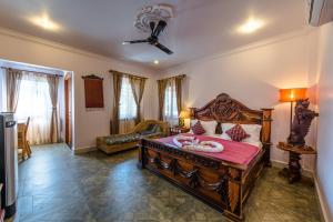a bedroom with a large wooden bed with a pink blanket at Delux Villa in Battambang