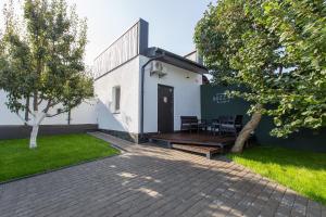 a house with a black door and a patio at Mini Hotel Buzzok in Kyiv