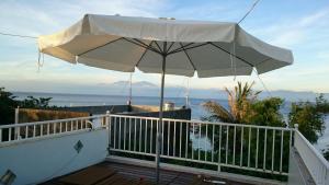 a white umbrella on the deck of a house at Divewhale Homestay in Xiaoliuqiu