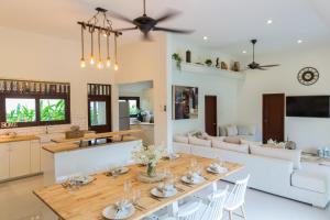 a dining room and living room with a table and chairs at Baan Lily in Chaweng