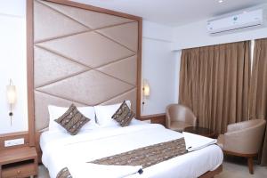 a hotel room with a bed with a large headboard at Shikin Hotels (Close to Palm Beach Road) in Navi Mumbai +32 photos