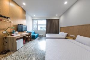 台南的住宿－吃飽睡好歡迎回家，酒店客房配有两张床和一张书桌