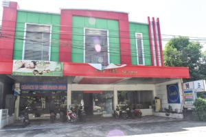 un edificio colorido con motocicletas estacionadas frente a él en RedDoorz near Universitas Muhammadiyah Makassar, en Makassar