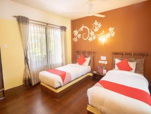 1 dormitorio con 2 camas y ventana en Chitwan Riverside Resort, en Sauraha