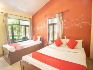 Chitwan Riverside Resort tesisinde bir odada yatak veya yataklar