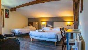 a hotel room with two beds and a table at Hotel Bellevue in Hendaye