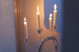 a bathroom sink with three candles in front of a mirror at Nid à bulles - Loft 35m2 sauna jacuzzi 10min centre Strasbourg in Bischheim
