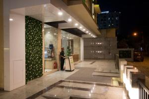 a man standing outside of a building at night at Hotel Wego in Mumbai