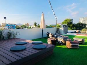 a backyard with a deck with chairs and an umbrella at Peranakan Boutique Hotel - SHA Plus in Phuket