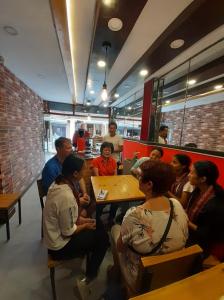 a group of people sitting at a table in a restaurant at Durbar Home Stay in Pātan