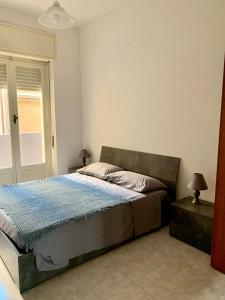 a bedroom with a bed with a blue comforter at Il Corso in Cagliari