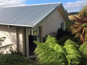 ein Haus mit einem Zinndach und grünen Pflanzen in der Unterkunft Forrest River Valley- Blue Wren Studio in Forrest