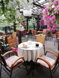 una mesa y sillas en un patio con flores en Zajazd Biały Młyn, en Sterławki Wielkie