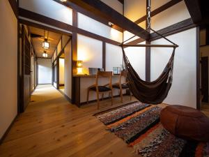 uma rede pendurada em uma sala com uma escrivaninha em 内子の宿 織 em Uchiko