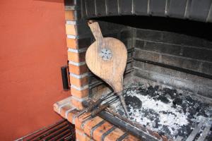 a wooden spatula sitting inside of a brick oven at Hostal Cervantes in Daganzo de Arriba