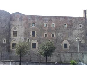 a large brick building with trees in front of it at Central Rooms Il Re in Catania
