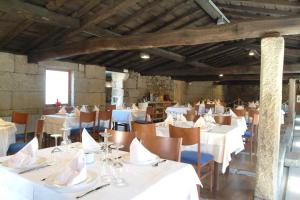 uma sala de jantar com mesas e cadeiras brancas em Casa Rural Vilaboa em Allariz