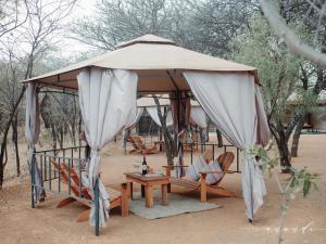 a gazebo with chairs and a table under it at Foreva Wild in Klipdrift