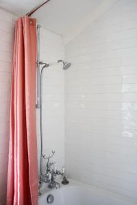 La salle de bains est pourvue d'une douche avec un rideau de douche rose. dans l'établissement Bloom Cottage, à Aldeburgh