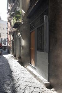 an alley with a building with a door and a street at Le sorelle di Napoli in Naples