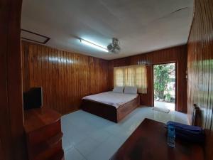 Song Lao Guesthouse في ثاكيك: غرفة نوم فيها سرير وتلفزيون