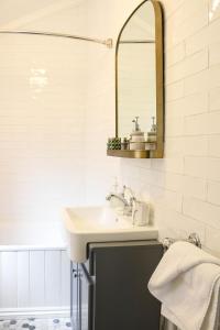 La salle de bains est pourvue d'un lavabo et d'un miroir. dans l'établissement Bloom Cottage, à Aldeburgh