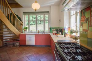 d'une cuisine avec cuisinière et évier et d'un escalier. dans l'établissement Villa Louisental - Gruppenunterkunft für Selbstversorger, au Hohwald