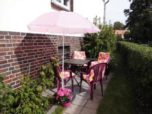 un tavolo da patio con due sedie e un ombrellone di Ferienwohnung am Hafen a Lübbenau