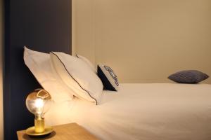 ein Bett mit Kissen und einer Lampe auf einem Tisch in der Unterkunft La Casa nel Parco in Neapel