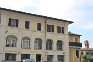 żółty budynek z oknami i samochodami zaparkowanymi przed nim w obiekcie Casa Sigiu - Il Fiume w mieście Rieti
