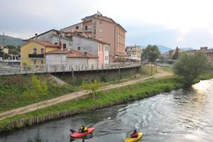 two people in kayaks on a river in a town at Casa Sigiu - Il Fiume in Rieti