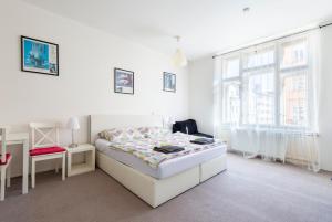 a bedroom with a bed and a desk and window at TopApartmany in Prague