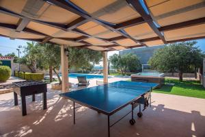 - une table de ping-pong sur une terrasse avec un parasol dans l'établissement Villa Paula with 7 bedrooms, heated 36sqm private pool, Jacuzzi, Gym and sea views, à Kaštela