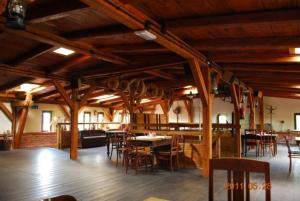 a large room with wooden ceilings and tables and chairs at Pensjonat Stary Spichlerz in Ełk