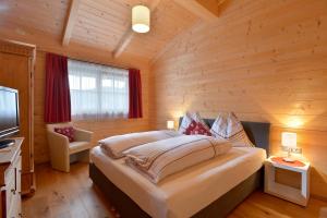 ein Schlafzimmer mit einem großen Bett in einer Holzhütte in der Unterkunft Ferienwohnung Lechenhof in Söll