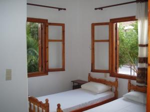 Eleni Studios & Apartments في ميثيمنا: سريرين في غرفة بها نافذتين