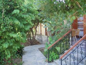 a walkway through a garden with trees and a fence at Eleni Studios & Apartments in Mithymna